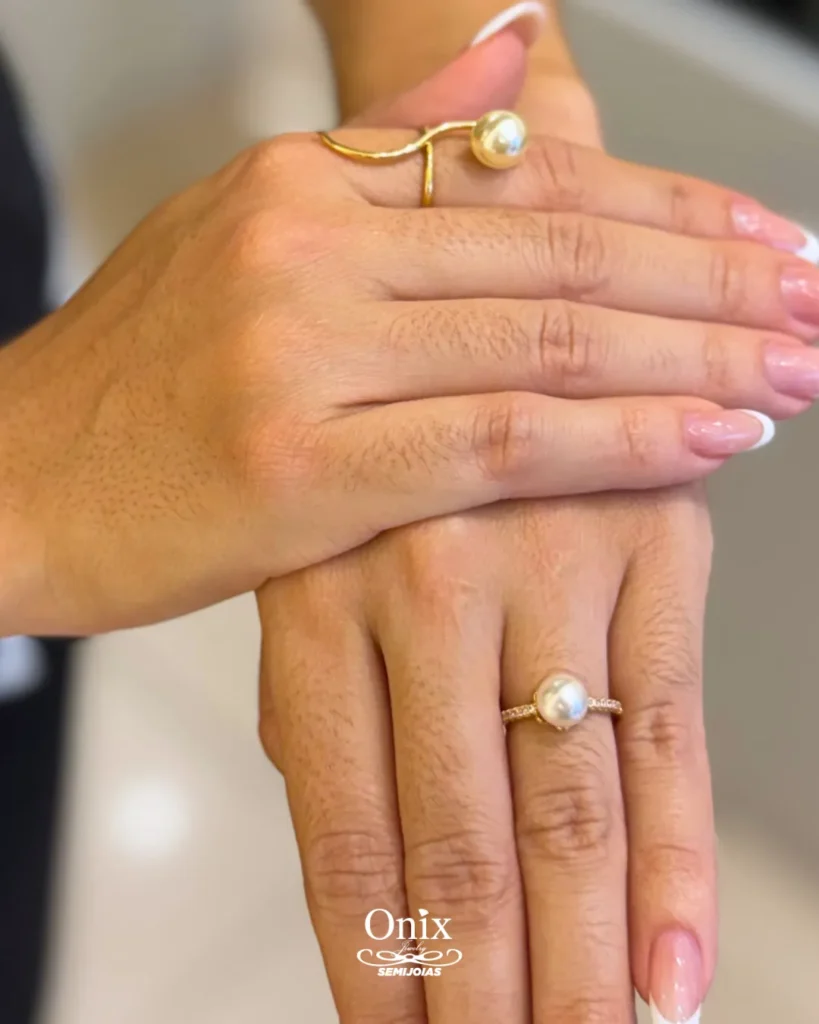 Mãos com anéis de pérola